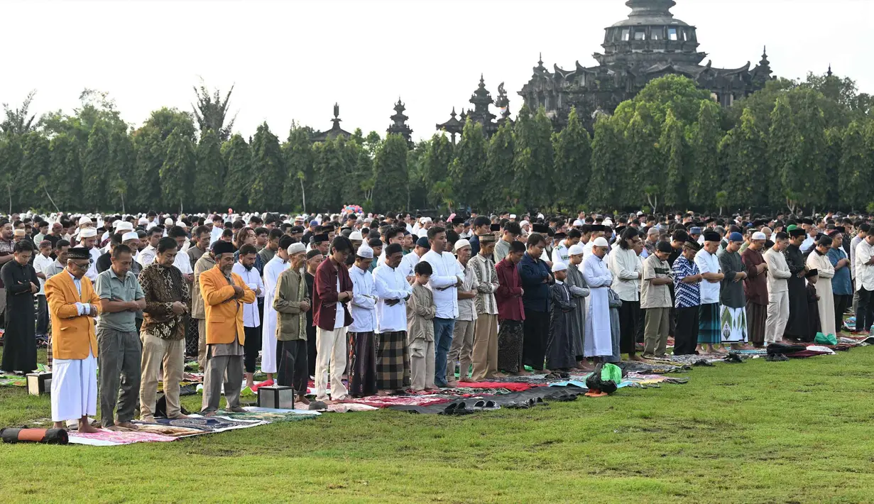 Pelaksanaan salat Idul Fitri berlangsung dengan khidmat di ribuan titik yang tersebar di berbagai wilayah, mulai dari lapangan terbuka hingga gedung-gedung dakwah. Tampak dalam foto, umat Muslim saat melaksanakan salat Idul Fitri 1447 Hijriah di monumen dan taman Bajra Sandhi di Denpasar, Bali, pada Jumat 20 Maret 2026. (SONNY TUMBELAKA/AFP)