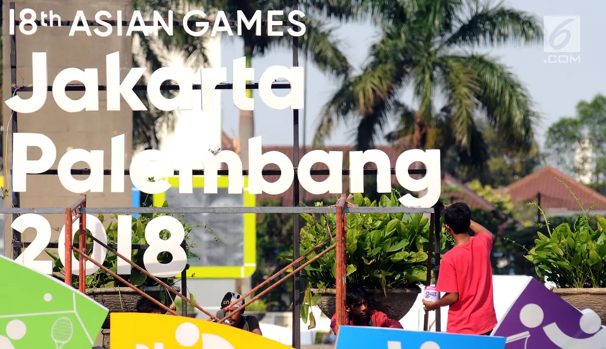 Pekerja menyelesaikan pemasangan logo Asian Games 2018 di kawasan Bundaran Hotel Indonesia, Jakarta, Rabu (16/8). Jelang peluncuran hitung mundur Asian Games 2018 pemasangan karakter cabang olahraga dipercepat. (Liputan6.com/Helmi Fithriansyah)