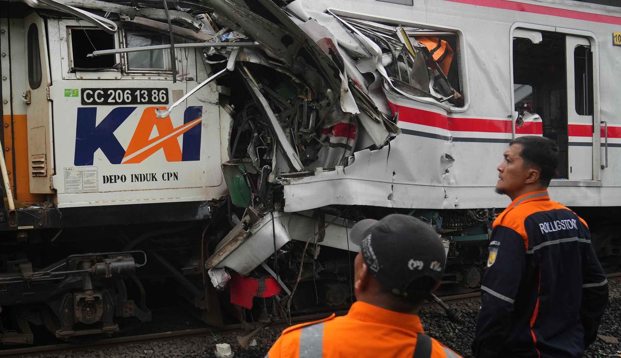 Para pekerja memeriksa kondisi lokomotif Kereta Api Jarak Jauh (KAJJ) Argo Bromo Anggrek dan salah satu gerbong Kereta Rel Listrik (KRL) Commuter Line yang mengalami kecelakaan di Stasiun Bekasi Timur, Bekasi, Jawa Barat, Selasa 28 April 2026. (AP Photo/Tatan Syuflana)