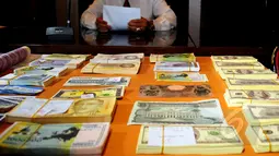 Tampak uang palsu asing diperlihatkan kepada wartawan di Mabes Polri, Jakarta, Kamis (9/4/2015). Uang palsu tersebut diperoleh dari empat tersangka yang ditangkap di wilayah Bogor.(Liputan6.com/Yoppy Renato)