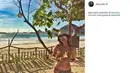 Aline Adita memanfaatkan liburnya dengan pergi ke Lombok. Pada salah satu postingan foto, Aline tampil seksi dengan mengenakan bikini yang dipadu dengan topi dan kacamata. (instagram.com/aline_adita)