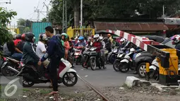 Pemotor menerobos palang pintu perlintasan kereta di kawasan Kemayoran, Jakarta, Kamis (6/10). Perilaku pengguna jalan yang tidak tertib seperti ini berisiko menimbulkan kecelakaan lalu lintas. (Liputan6.com/Immanuel Antonius)