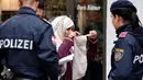 Seorang wanita Muslim dipaksa oleh Polisi Austria melepaskan cadarnya di kota Zell am See, Minggu (1/10). Undang-undang di Austria menyebutkan bahwa menutupi wajah di tempat umum akan dikenai sanksi dan denda sekira Rp2,4 juta. (BARBARA GINDL/APA/AFP)