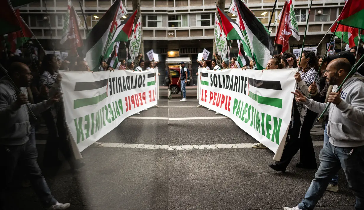 Saat berunjuk rasa, mereka membawa bendera Palestina sambil meneriakkan tuntutan. (Lionel BONAVENTURE/AFP)