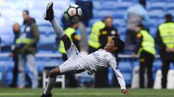Putra dari Cristiano Ronaldo melakukan tendangan salto saat menemani sang ayah di Stadion Santiago Bernabeu, Madrid, Minggu (8/4/2018). Tendangan ini mirip seperti saat CR 7 membobol gawang Juventus. (AFP/Gabriel Bouys).