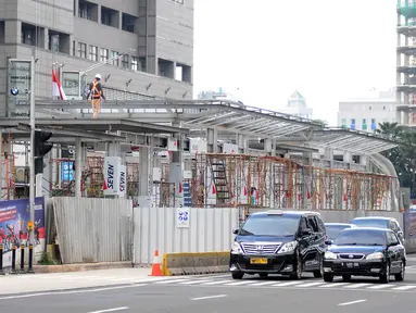 Kendaraan melintas saat pekerja menyelesaikan proyek pembangunan Halte Transjakarta Bundaran HI di Jakarta, Sabtu (9/3). Setelah sempat dibongkar untuk proyek MRT, Pemprov DKI kembali membangun Halte Transjakarta Bundaran HI. (Liputan6.com/HermanZakharia)