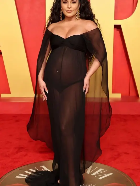 Vanessa Hudgens tampil dengan gaun hitam transparan model off shoulder yang memamerkan baby bumpnya. [@vanessahudgens]