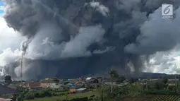 Rumah warga terlihat dengan latar belakang Gunung Sinabung yang menyemburkan awan panas di Kabupaten Karo, Provinsi Sumatera Utara, Rabu (27/12). (Liputan6.com/Pool/BNPB)