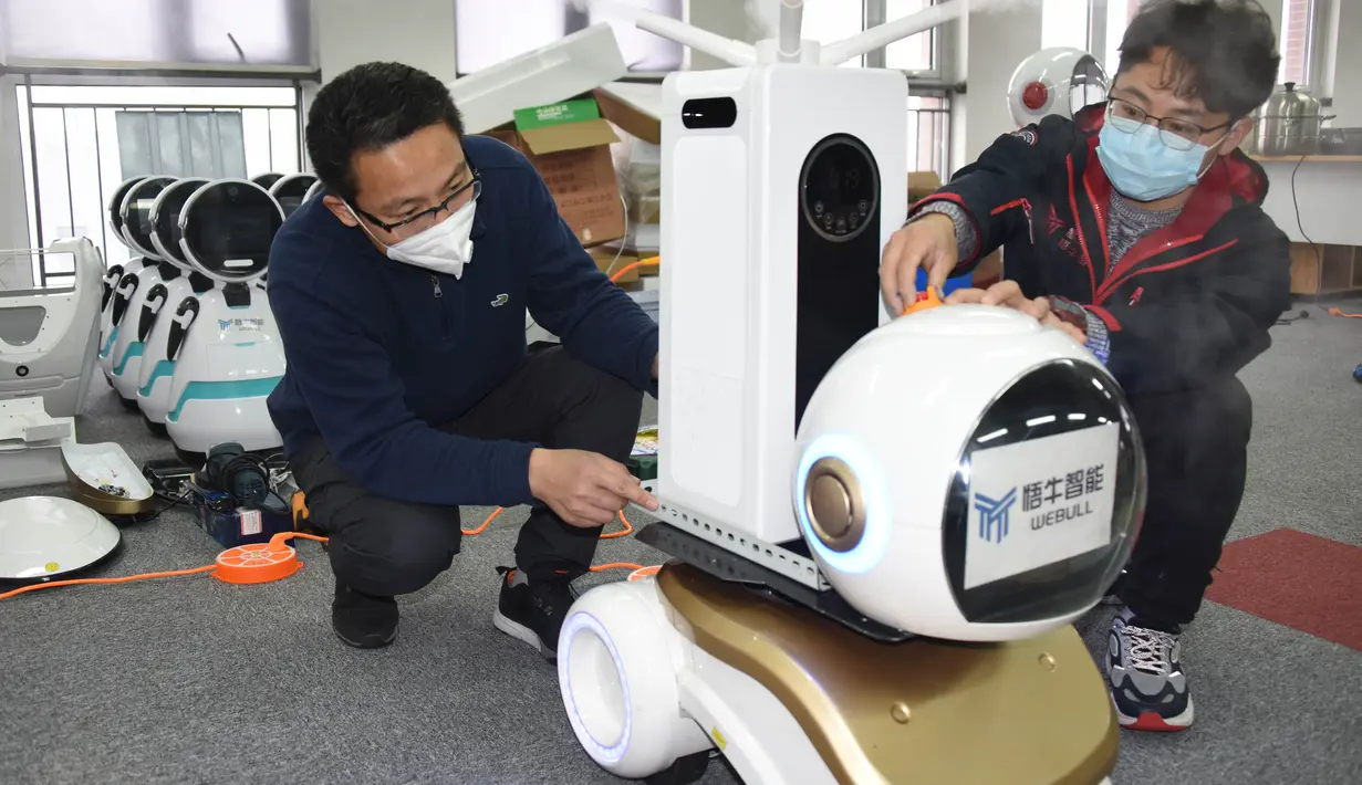 Para teknisi menyetel robot desinfeksi generasi kedua di sebuah perusahaan teknologi di Qingdao, Provinsi Shandong, China, 11 Februari 2020. Beberapa robot desinfeksi ini telah digunakan di ruang isolasi sejumlah rumah sakit di China. (Xinhua/Li Ziheng)