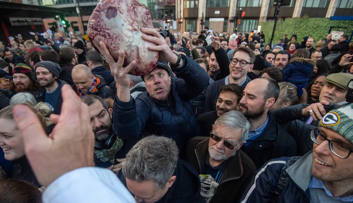 Pembeli mendapatkan daging selama lelang tahunan di Smithfield Market, kota London, 24 Desember 2018. Dalam tradisi Natal yang hadir sejak 1800-an, calon pembeli bisa menawar harga daging tersebut. (NIKLAS HALLE'N/AFP)