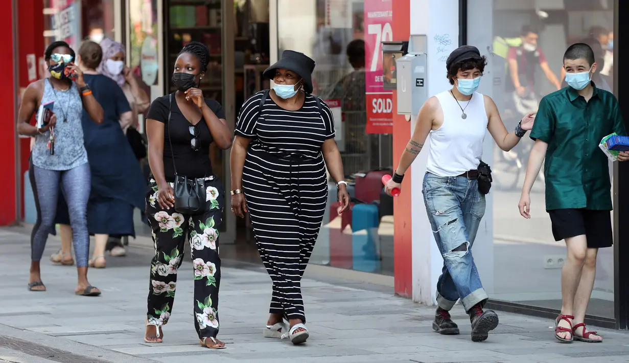 Orang-orang memakai masker saat berjalan di Brussel, Belgia, Rabu (12/8/2020). Penggunaan masker menjadi wajib di tempat umum di Brussel karena kasus Covid-19 naik ke tingkat kewaspadaan yang menempatkan kota itu di antara yang paling parah terkena dampak corona di Eropa. (François WALSCHAERTS/AFP)