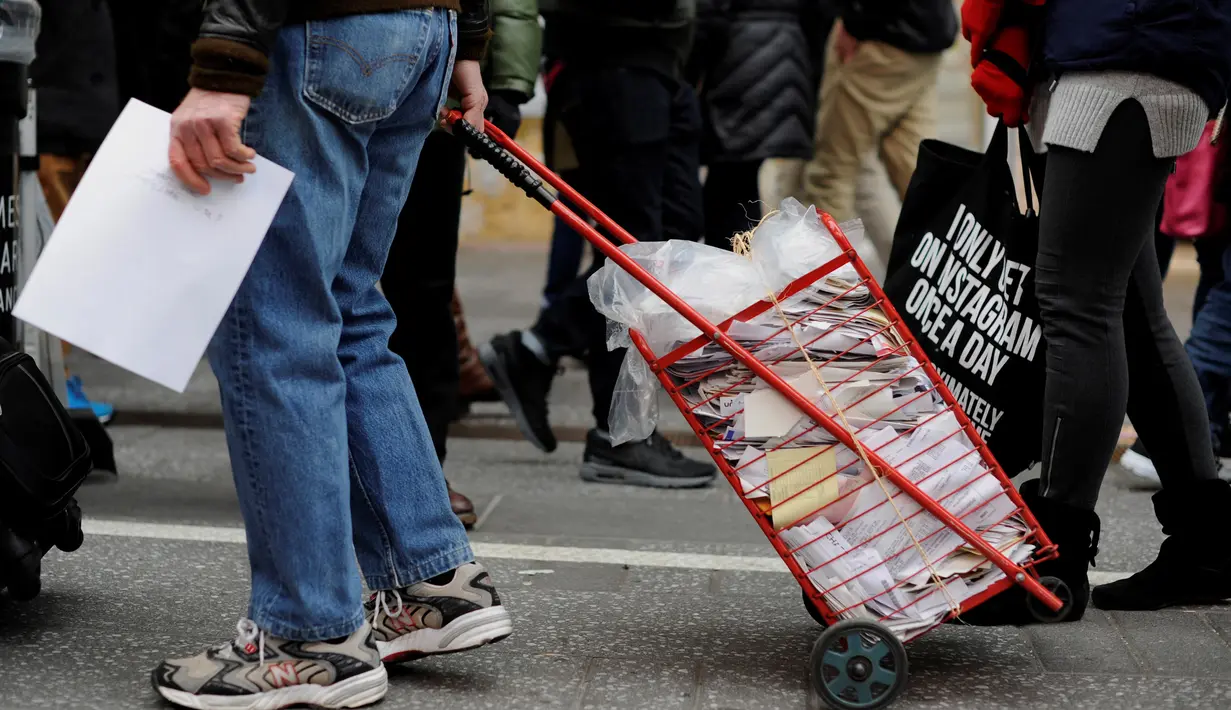 Warga mengantre untuk menghancurkan setumpuk rekening dalam "Good Riddance Day" di Times Square, New York, Rabu (28/12). Mereka berkumpul membuang barang-barang yang mengingatkan pada kenangan buruk menjelang pergantian tahun. (REUTERS/Darren Ornitz)