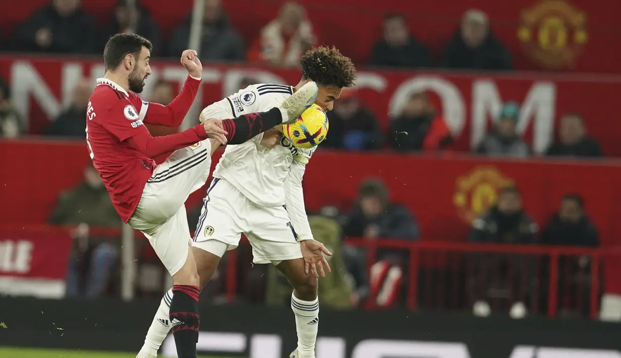 Gelandang Manchester United (MU) Bruno Fernandes mengangkat kakinya untuk mengejar bola ketika bersaing dengan gelandang Leeds United Tyler Adams pada laga tunda pekan ke-8 Liga Inggris 2022/2023 di Old Trafford, Kamis (9/2/2023) dini hari WIB. MU gagal mendulang poin penuh saat tampil di Old Trafford. (AP Photo/Dave Thompson)