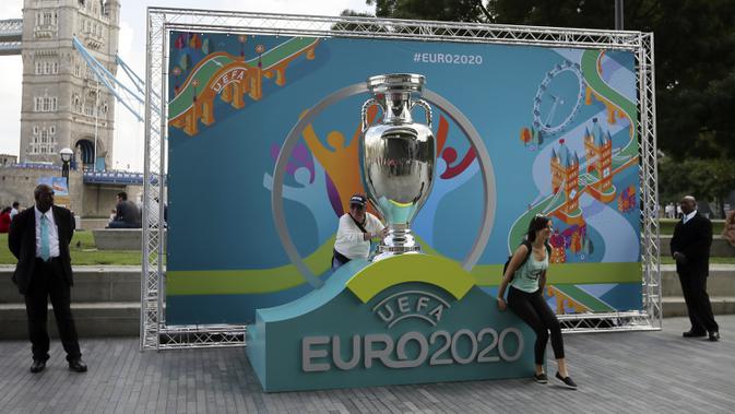 Warga berpose dengan logo Piala Eropa 2020 saat  peluncuran di London, Inggris, 21 September 2016. UEFA memundurkan jadwal Piala Eropa 2020 hingga tahun 2021. (AP Photo/Tim Ireland, File)