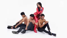 Penyanyi Denada mengenakan baju merah ketat dan sepatu boot berwarna senada. bersama tiga laki-laki yang sedang duduk dalam kondisi topless denada bergoyang di single terbarunya bertajuk "Mutha Futha". (Instagram/@denadaindonesia)