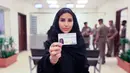 Esraa Albuti menunjukkan surat izin mengemudi (SIM) miliknya di Departemen Lalu Lintas Umum di ibu kota Riyadh, Senin (4/6). Pemerintah Arab Saudi resmi mengeluarkan lisensi mengemudi untuk para wanita di sana. (Saudi Information Ministry via AP)