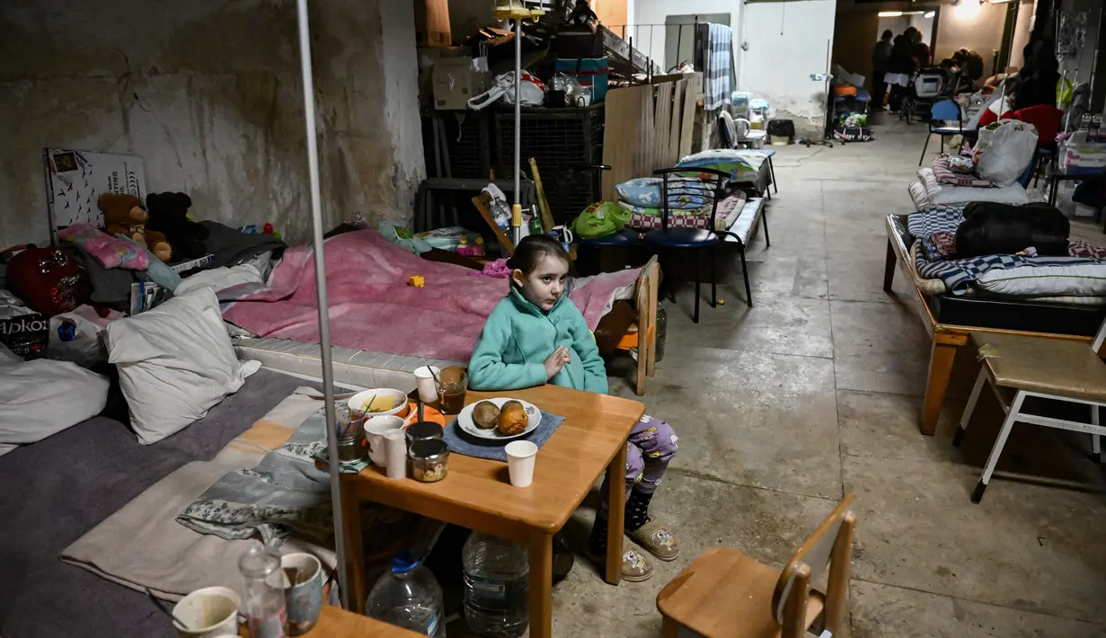 Anak-anak yang dirawat di rumah sakit pediatri ditempatkan tempat tidur mereka di ruang bawah tanah rumah sakit yang digunakan sebagai tempat perlindungan bom di Kiev, Senin (28/2/2022). Tentara Rusia mengatakan, warga sipil Ukraina dapat meninggalkan ibu kota Kiev dengan bebas. (Aris Messinis / AFP