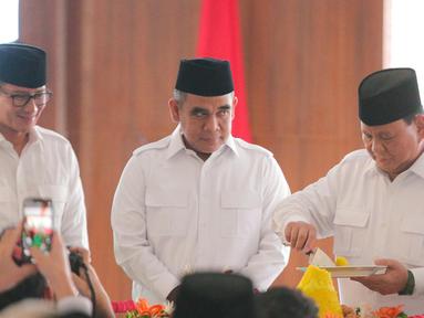 Ketua Umum Partai Gerindra, Prabowo Subianto (kanan) memotong tumpeng disaksikan Wakil Ketua Dewan Pembina Partai Gerindra Sandiaga Uno (kiri) dan Sekretaris Jenderal Gerindra Ahmad Muzani (tengah) saat perayaan HUT ke-15 Partai Gerindra, di Kantor DPP Partai Gerindra, Jakarta, Senin (6/2/2023). HUT ke-15 Partai Gerindra merupakan momen berharga karena dilaksanakan sebelum Pemilu 2024 dan juga untuk melakukan konsolidasi internal untuk semakin memperkuat kekuatan partai. (Liputan6.com/Faizal Fanani)