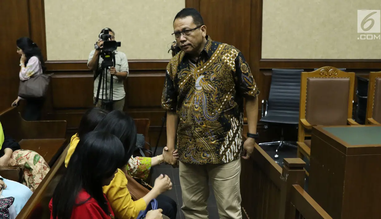 Terdakwa suap pengadaan dan pelaksanaan pembangunan kampus IPDN Sumbar Kab Agam 2011, Dudy Jocom memegang tangan keluarganya usai sidang putusan di Pengadilan Tipikor Jakarta, Rabu (14/11). Dudy divonis 4 tahun penjara. (Liputan6.com/Helmi Fithriansyah)