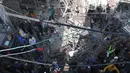 Orang-orang berkumpul di sekitar bangunan yang dirusak dan dibakar oleh pasukan Israel selama penggerebekan di kamp pengungsi Jenin Tepi Barat, pada 26 Januari 2023. Serangan Israel di kamp pengungsi Jenin hari ini menewaskan 9 warga Palestina termasuk seorang wanita lanjut usia, kata pejabat Palestina. (AFP/Jaafar Ashtiyeh)