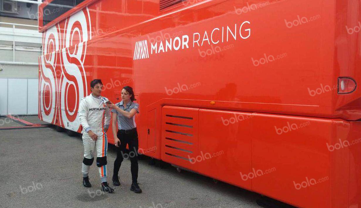 Pebalap Manor Racing asal Indonesia, Rio Haryanto, bersama media officer Manor Racing seusai latihan bebas kedua F1 GP Spanyol di Sirkuit Catalunya, Spanyol, Jumat (13/5/2016). (Bola.com/Reza Khomaini)