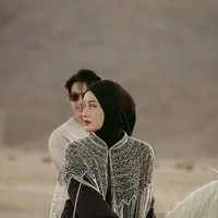 Dalam pemotretan di tengah padang pasir yang eksotis, Rey Mbayang dan Dinda Hauw tampil serasi dalam balutan outfit yang stylish dan tetap nyaman untuk berkuda. [@dindahw].