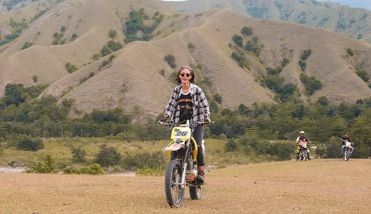 Momen seru Della dengan motor trail saat berkunjung di  Ollon, Buakayu, Bonggakaradeng, Toraja. Bergaya tomboi dengan kemeja flanel, wanita yang akan berperan sebagai Nila Umaya di Jagat Sinema Bumilangit  ini tampak bahagia. (Liputan6.com/IG/delladartyan)