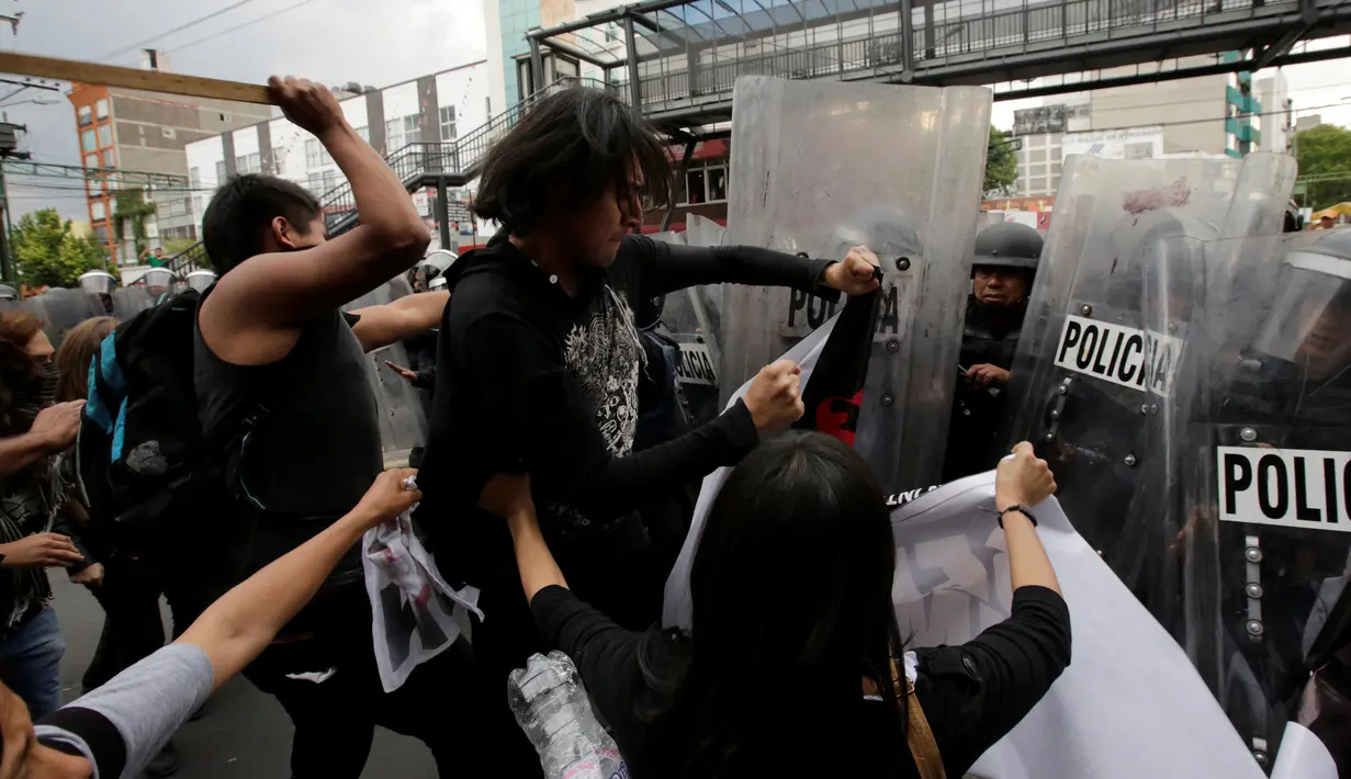 Sejumlah demonstran saat bentrok dengan polisi anti huru hara menentang adu banteng di luar arena adu banteng di Mexico City, Meksiko 29 Mei 2016. (REUTERS / Henry Romero)