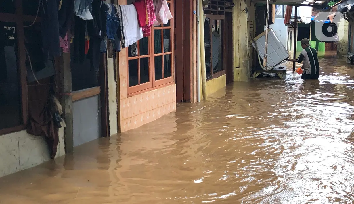 Warga beraktivitas di tengah banjir yang merendam kawasan Kebon Pala, Jakarta Timur, Selasa (25/2/2020). Akibat banjir yang tak kunjung surut, aktivitas warga di kawasan tersebut menjadi terganggu, terlebih dengan adanya pemadaman listrik. (Liputan6.com/Immanuel Antonius)