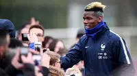 Gelandang timnas Prancis Paul Pogba menyapa penggemar sebelum mengikuti sesi latihan di Clairefontaine-en-Yvelines, Paris (19/3). Pogba bersama timnas Prancis melakukan latihan jelang pertandingan persahabatan. (AFP Photo/Franck Fife)