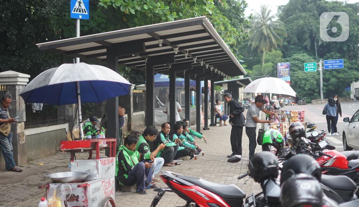 Pengemudi ojek daring menunggu order di depan Cibubur Junction, Jakarta, Selasa (24/3/2020). Merebaknya corona Covid-19 menyebabkan aktivitas di kawasan itu lesu yang juga berimbas pada turunnya pendapatan pengemudi ojol hingga lima kali lipat dibanding hari biasanya (Liputan6.com/Immanuel Antonius)