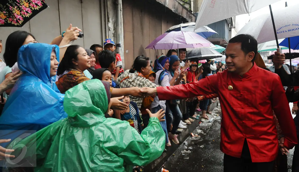 Walikota Bogor, Bima Arya Sugiarto menyalami warga saat mengikuti parade Pesta Rakyat dan perayaan Cap Go Meh di Kota Bogor, Senin (22/2/2016). Pesta Rakyat Bogor 2016 bersamaan dengan  perayaan Cap Go Meh. (Liputan6.com/Helmi Fithriansyah)