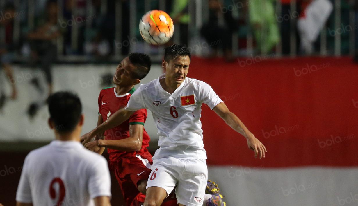 Pemain Timnas Indonesia, Abdul Rachman (kiri) berduel dengan pemain Vietnam pada laga uji coba di Stadion Maguwoharjo, Sleman, Minggu (09/10/2016). (Bola.com/Nicklas Hanoatubun)