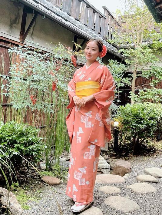 Berpose di pekarangan rumah, Natasha Wilona ini tampil anggun pakai kimono peach dan obi kuning. [@natashawilona12].