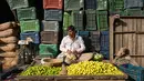 Seorang pegadang memasukan lemon kedalam plastik saat dia menunggu pelanggan di pasar grosir buah dan sayuran di New Delhi, India (27/3). Dari pasar tradisional hingga mal megah modern, Delhi memiliki segalanya untuk ditawarkan kepada pelanggan. (AFP Photo/Noemi Cassanelli)