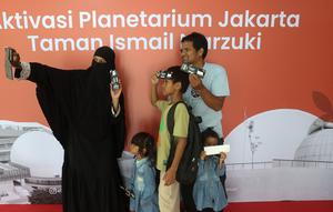 Pengunjung berswafoto sebelum memasuki area Planetarium di Taman Ismail Marzuki, Jakarta, Kamis (25/12/2025). Planetarium Taman Ismail Marzuki (TIM) akhirnya dibuka kembali. Planetarium Taman Ismail Marzuki (TIM) akhirnya dibuka kembali. (Kapanlagi.com/Budy Santoso)