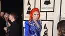 Gaun panjang bergaya mantel yang terjuntai panjang menyapu lantai ini merupakan rancangan Marc Jacobs. Gaya Lady Gaga dengan warna rambut api serta gaun biru ini terinspirasi dari cover album ‘Aladdin Sane’ David Bowie. (AFP/Bintang.com)