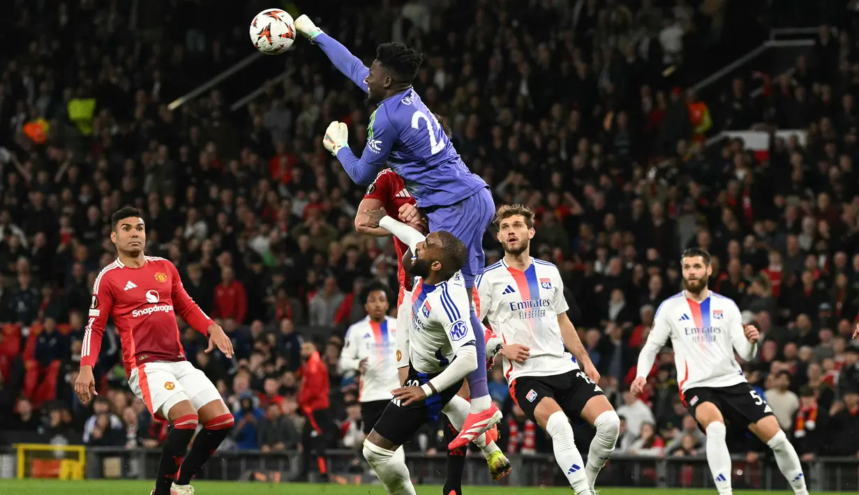 Kiper Manchester United, Andre Onana berusaha menghalau bola dalam laga lanjutan Liga Europa 2024/2025 melawan Lyon di Old Trafford, Manchester, Inggris, Jumat (18/04/2025) dini hari WIB. (AFP/Oli Scarff)