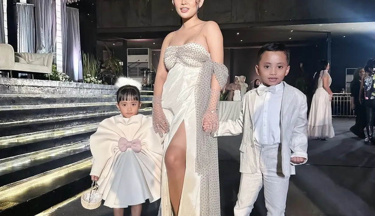 Ia juga menambahkan gloves transparan motif polkadot. Rambutnya diikat ke belakang dengan riasan serba pink dari blush on dan lipstiknya.  (@rachelvennya)