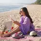 Mengikuti tren masa kini, Jessica Mila pun menggelar kain untuk piknik di pantai. Di momen pikniknya kali ini, ia nampak mengenakan jumpsuit warna ungu lilac dan mengenakan riasan natural. (Liputan6.com/IG/jscmila)