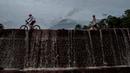 Penduduk desa melewati Gunung Semeru sehari setelah erupsi di Lumajang, Jawa Timur, pada Minggu (17/1/2021). Kendati demikian, Pusat Vulkanologi dan Mitigasi Bencana Geologi ( PVMBG) menegaskan status Semeru masih level II atau Waspada. (Juni Kriswanto / AFP)