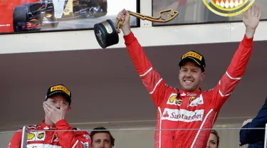 Pembalap Ferrari asal Jerman, Sebastian Vettel mengangkat trofi saat merayakan kemenangannya pada balapan GP Monaco di Sirkuit Monte Carlo, Minggu (28/5). Vettel finis pada urutan pertama dengan waktu satu jam 44 menit 44,340 detik (AP Photo/Claude Paris)