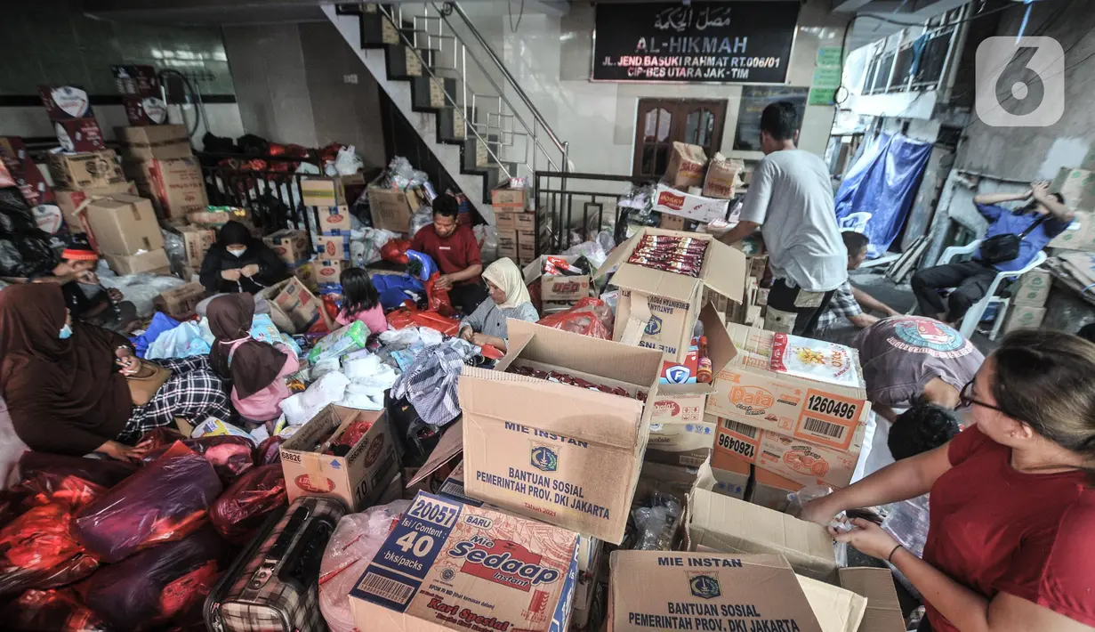 Warga merapikan bantuan logistik di RW 01 Pasar Gembrong, Kelurahan Cipinang Besar Utara, Kecamatan Jatinegara, Jakarta Timur, Rabu (11/5/2022). Berdasarkan data termutakhir, terdapat 185 rumah dengan 432 keluarga yang terdiri dari 691 jiwa terdampak kebakaran tersebut. (merdeka.com/Iqbal S. Nugroho)