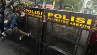 Salah satu pengunjuk rasa mencoba membuka blokade aparat keamanan saat berunjuk rasa di kawasan jalan Jenderal Sudirman, Jakarta, Jumat (12/6/2026). (merdeka.com/Arie Basuki)