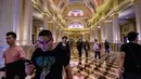 Wisatawan berjalan dalam resor kasino The Venetian di Macau, 5 Maret 2019. Sekitar 20 persen orang yang tinggal di Macau bekerja di kasino. (Anthony Wallace/AFP)