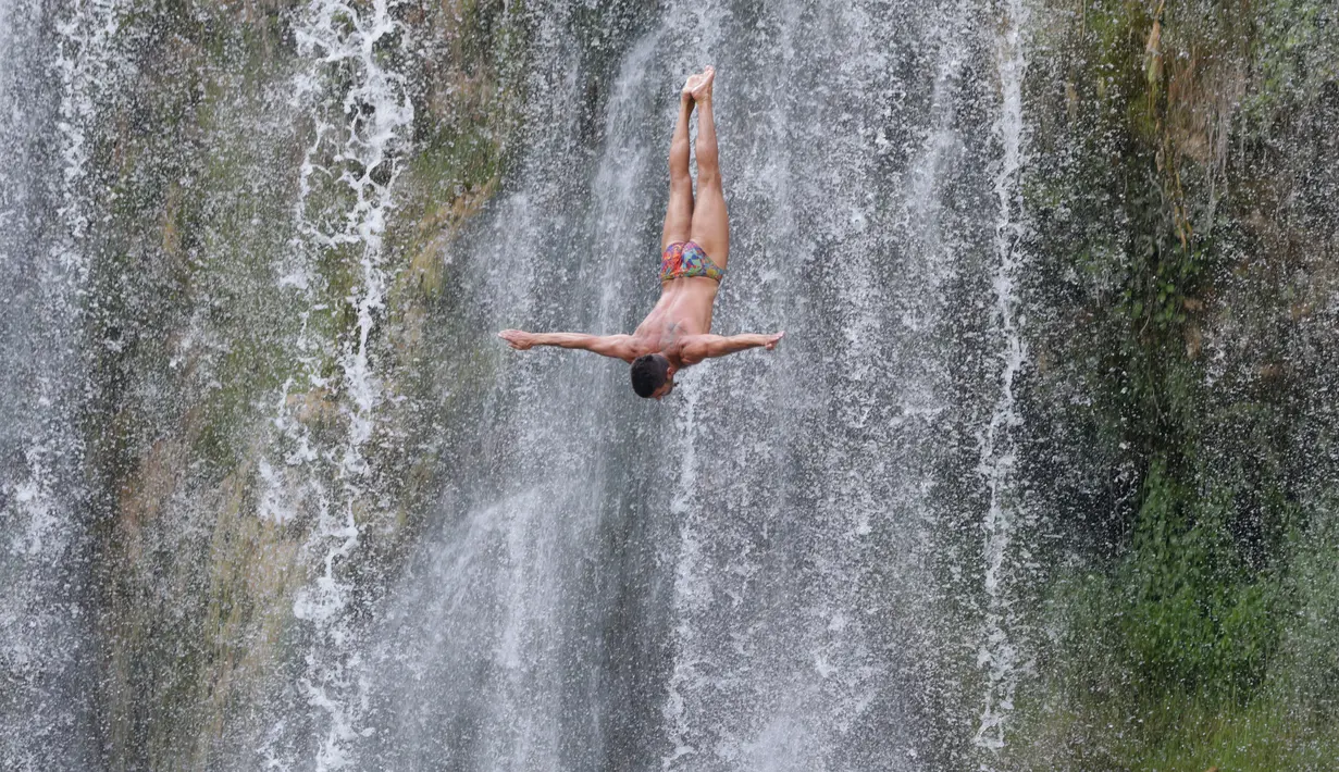 Gaya peserta saat melakukan lompatan dari atas air terjun dalam mengikuti lomba melompat air terjun internasional ke-4 di Kota Jajce, Bosnia (5/8). Lomba melompat dari atas air terjun internasional ini telah digelar 4 kali.  (AP Photo/Amel Emric)