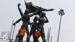 Pekerja menggosok bagian dari Patung Ikada di kawasan Monas, Jakarta, Selasa (22/11). Pembersihan dilakukan untuk melestarikan bangunan cagar budaya tersebut agar tetap terawat. (Liputan6.com/Immanuel Antonius)