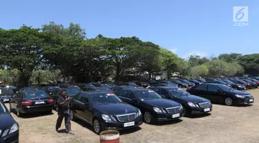 Seorang supir berjalan di antara mobil Toyota Camry dan Mercy E200 di Lapangan Lagoon Bali, Nusa Dua, Selasa (9/10). Sebanyak 865 unit kendaraan disiapkan untuk mengangkut delegasi Pertemuan Tahunan IMF-World Bank di Bali. (Liputan6.com/Angga Yuniar)