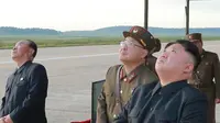 Pemimpin Korea Utara, Kim Jong-Un menyaksikan uji coba peluncuran rudal balistik Hwasong-12 di lokasi yang tidak diketahui pada foto yang dirilis Sabtu (16/9). Rudal Hwasong-12 Korut ditembakkan menerobos langit Hokkaido, Jepang (STR / KCNA VIA KNS / AFP)