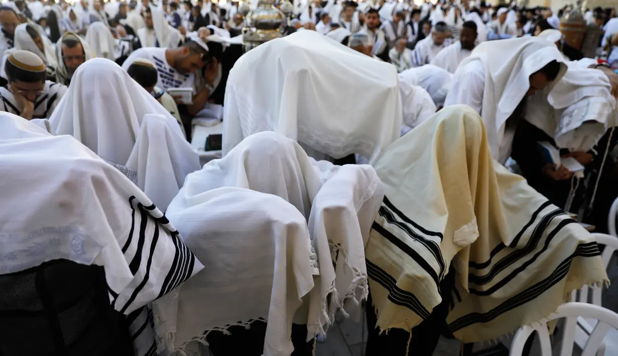 Pemandangan saat ribuan umat Yahudi menggelar doa di Tembok Barat Kota Tua Yerusalem, Senin (2/4). Ritual mengingat penderitaan bangsa Israel saat eksodus dari Mesir ini dilakukan dengan menahan diri dari makan produk makanan beragi. (MENAHEM KAHANA/AFP)